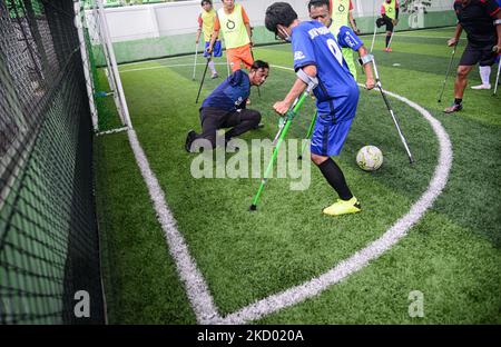 I giocatori della squadra di calcio degli amputei di Asprov West Java che usano le stampelle giocano una partita di calcio durante una sessione di allenamento in un campo a Bogor il 9 gennaio 2022. (Foto di Adriana Adie/NurPhoto) Foto Stock