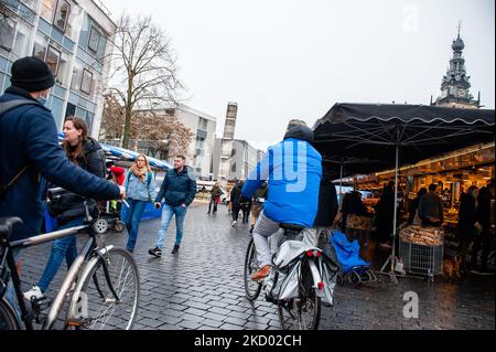 Le persone camminano e sulle loro biciclette attraverso il mercato settimanale per le strade, durante il duro blocco imposto nel paese. A Nijmegen, il 8th gennaio 2022. (Foto di Romy Arroyo Fernandez/NurPhoto) Foto Stock