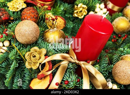 Decorazioni natalizie, composizione festosa con rami di pino naturale, candela, nastro e baubles. Bellissimo ornamento di lusso di albero di Natale Foto Stock