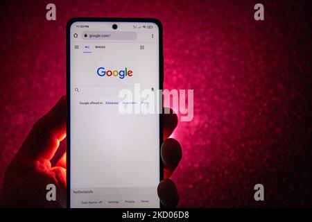 Logo Google su uno smartphone tenuto da una mano con sfondo rosso scuro. Logo Google closeup visualizzato su uno schermo del telefono, smartphone il logo o il motore di ricerca in vari sfondi come la tastiera, la texture illuminata scura o uno schermo del computer, come si vede in questa illustrazione di esposizione multipla, il simbolo dell'azienda è riconosciuto a livello globale. Google, LLC è un colosso tecnologico americano, una multinazionale che si specializza nei servizi e nei prodotti connessi a Internet, che includono le tecnologie di pubblicità online, un motore di ricerca, il cloud computing, il software e l'hardware. È considerato o Foto Stock