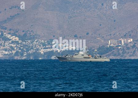 Una nave di pattuglia greca della Marina ellenica sta pattugliando i confini dell'acqua del Mar Egeo tra la Grecia e la Turchia, appena fuori dall'isola di Kos con la Turchia sullo sfondo con case estive, resort e alberghi visibili. I pattugliamenti sono destinati a scopi militari, ma anche a imbarcazioni con rifugiati e migranti, oltre alla forza FRONTEX che protegge i confini europei dalla crisi dei rifugiati. La nave che pattuglia i richiedenti asilo che cercano di attraversare con un gommone della costa turca è una piccola nave missilistica di classe Diopos Antoniou P286 Hellenic Navys Kelefstis Stamou. L'isola di Kos e la costa turca fr Foto Stock