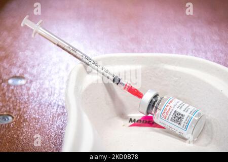 Primo piano sulla siringa e sul flaconcino del vaccino di moderna con l'iscrizione di moderna. L'operatore sanitario pubblico GGD prepara i vaccini Moderna Spikevax mRNA Covid-19 prelevandoli dal flacone di vetro del flaconcino alle singole dosi nelle siringhe nell'area speciale del mega centro di vaccinazione di Eindhoven. I jab sono somministrati come dose di richiamo. Il richiamo della terza dose è disponibile per tutti i Paesi Bassi oltre al blocco mentre la nazione combatte le epidemie della nuova mutazione del coronavirus variante di omicron della pandemia. Eindhoven, Paesi Bassi il 7 gennaio 2022 (Foto b Foto Stock