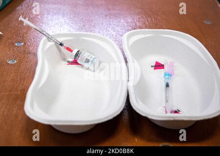 Primo piano sulla siringa e sul flaconcino del vaccino di moderna con l'iscrizione di moderna. L'operatore sanitario pubblico GGD prepara i vaccini Moderna Spikevax mRNA Covid-19 prelevandoli dal flacone di vetro del flaconcino alle singole dosi nelle siringhe nell'area speciale del mega centro di vaccinazione di Eindhoven. I jab sono somministrati come dose di richiamo. Il richiamo della terza dose è disponibile per tutti i Paesi Bassi oltre al blocco mentre la nazione combatte le epidemie della nuova mutazione del coronavirus variante di omicron della pandemia. Eindhoven, Paesi Bassi il 7 gennaio 2022 (Foto b Foto Stock