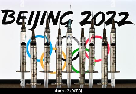 Foto illustrativa delle siringhe mediche viste di fronte agli anelli olimpici e al logo di Pechino 2022 visualizzato sullo schermo di un computer. Giovedì 14 gennaio 2021, a Edmonton, Alberta, Canada. (Foto di Artur Widak/NurPhoto) Foto Stock