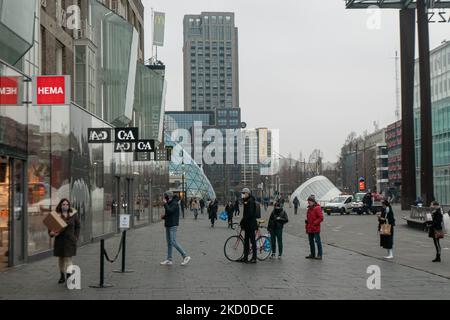 In linea con le persone in attesa di ottenere i loro prodotti tramite il metodo Click and Collect. I Paesi Bassi sollevano in parte le misure di blocco dal 15 gennaio dopo la chiusura di 4 settimane, con tutti i negozi non essenziali che aprono con orario di lavoro limitato, università, parrucchieri e palestre, con capacità ridotta, ma caffè, bar e ristoranti resteranno sicuramente chiusi fino al 25 gennaio, un'azione che trova molti proprietari di negozio contro. Vita quotidiana a Eindhoven, mentre la gente cammina nel quartiere commerciale del centro o attendere in fila per ricevere i prodotti dai negozi tramite clic e raccogliere m Foto Stock