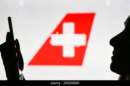 Immagine di una donna che tiene un telefono cellulare davanti al logo Swiss International Air Lines visualizzato sullo schermo di un computer. Martedì 12 gennaio 2021, a Edmonton, Alberta, Canada. (Foto di Artur Widak/NurPhoto) Foto Stock