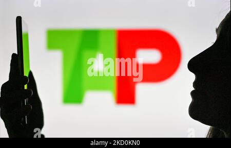 Immagine di una donna che tiene un telefono cellulare davanti al logo TAP Air Portugal visualizzato sullo schermo di un computer. Martedì 12 gennaio 2021, a Edmonton, Alberta, Canada. (Foto di Artur Widak/NurPhoto) Foto Stock