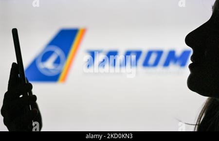 Immagine di una donna che tiene un telefono cellulare davanti al logo TAROM Airline visualizzato sullo schermo di un computer. Martedì 12 gennaio 2021, a Edmonton, Alberta, Canada. (Foto di Artur Widak/NurPhoto) Foto Stock