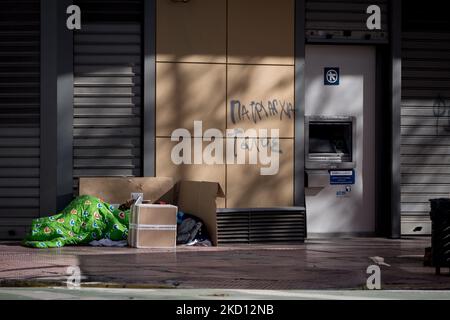 I senzatetto dormono davanti a una banca nel centro di Atene, in Grecia, il 23 gennaio 2022. (Foto di Nikolas Kokovlis/NurPhoto) Foto Stock