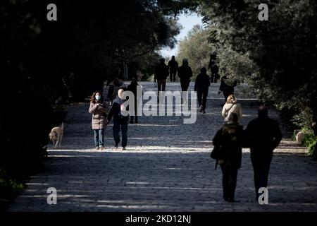 Il 23 gennaio 2022, la gente cammina al tacco dell'Acropoli indossando una maschera protetta ad Atene, in Grecia. (Foto di Nikolas Kokovlis/NurPhoto) Foto Stock