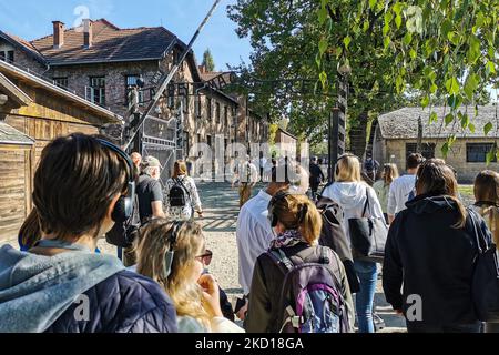 I visitatori camminano attraverso il cancello d'ingresso con l'iscrizione "Arbeit Macht Frei" nell'ex campo di concentramento nazista di Auschwitz i presso il sito commemorativo di Auschwitz. Oswiecim, Polonia il 4 ottobre 2021. (Foto di Beata Zawrzel/NurPhoto) Foto Stock