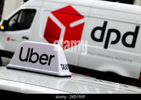 Il segno Uber sul tetto di un'auto e il logo DPD su un camion di consegna sono visibili sulla strada a Cracovia, in Polonia, il 26 gennaio 2022. (Foto di Jakub Porzycki/NurPhoto) Foto Stock