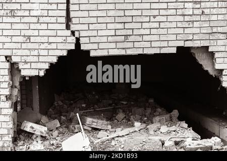 Muro esterno in mattoni con danni estremi crepe che trattengono dalla collisione del veicolo.Seppia foto in bianco e nero astratto foto di sfondo. Foto Stock