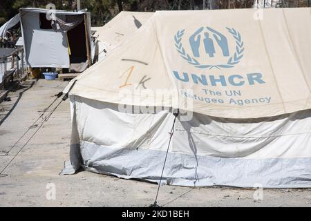 Tende bianche nel campo ufficiale con il logo dell'Agenzia delle Nazioni Unite per i rifugiati (UNHCR). L'ex campo ufficiale di rifugiati - migranti circondato da recinzione spinato di filo metallico a Vathy di Samos Island e il vicino campo di fortuna con tende fatte a mano e alcuni dall'UNHCR che si trova proprio accanto alle case della città di Vathi, come visto deserito. Il campo è stato svuotato e le persone sono state trasferite o spostate con la scorta della polizia al nuovo campo e alcune pochissime case. Una volta questa struttura ha ospitato al suo picco di 7500 richiedenti asilo presso le strutture ufficiali, ma anche il campo di fortuna nella foresta che è stato soprannominato il Jun Foto Stock