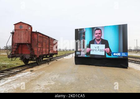Una carrozza ferroviaria originale usata per le deportazioni e uno schermo che mostra i video del Congresso Mondiale Ebraico per il 77th° anniversario di Auschwitz - Liberazione di Birkenau sono visti nel campo di concentramento e sterminio nazista-tedesco di Auschwitz II-Birkenau a Brzezinka, vicino a Oswiecim, Polonia, il 27 gennaio 2022. (Foto di Beata Zawrzel/NurPhoto) Foto Stock