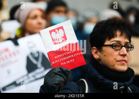 Una donna detiene una copia della Costituzione della Repubblica di Polonia durante una protesta di fronte a un tribunale a sostegno dell'indefenenza giudicale in Polonia. Cracovia, Polonia il 18 gennaio 2022. Alcuni giudici di spicco sono stati sospesi dai loro doveri di ufficio pubblico dopo aver protestato contro la revisione del sistema giudiziario da parte del governo, che è stata condannata come violazione dello stato di diritto da un’ampia gamma di istituzioni internazionali e organismi di esperti. (Foto di Beata Zawrzel/NurPhoto) Foto Stock