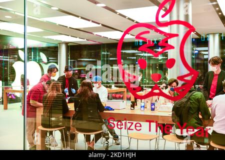 Hong Kong, Cina, 30 gennaio 2022, una decorazione del capodanno lunare ispirata alla Apple è vista sulla finestra dell'Apple Store del centro commerciale IFC con la scritta "Size the Year", mentre i clienti esaminano i prodotti Apple con i fornitori di magliette rosse. (Foto di Marc Fernandes/NurPhoto) Foto Stock