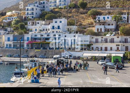 Scena del porto dell'isola con alcune piccole barche ormeggiate. Livadia, il porto e il villaggio principale dell'isola di Tilos con le case di architettura tradizionale imbiancate e la spiaggia con le acque cristalline del mare. Telos è una piccola isola greca mediterranea nel Mar Egeo, parte delle isole Dodecanesi, con una popolazione di 780 abitanti vicino alla costa turca. Alla fine del 2018 Tilos è diventata la prima isola del Mediterraneo a funzionare esclusivamente con energia eolica e solare, un'isola verde autosufficiente, un'iniziativa finanziata dall'UE per l'energia verde da fonti rinnovabili che proteggono il natu Foto Stock