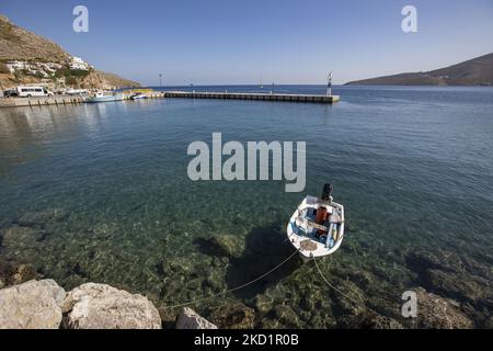 Scena del porto dell'isola con alcune piccole barche ormeggiate. Livadia, il porto e il villaggio principale dell'isola di Tilos con le case di architettura tradizionale imbiancate e la spiaggia con le acque cristalline del mare. Telos è una piccola isola greca mediterranea nel Mar Egeo, parte delle isole Dodecanesi, con una popolazione di 780 abitanti vicino alla costa turca. Alla fine del 2018 Tilos è diventata la prima isola del Mediterraneo a funzionare esclusivamente con energia eolica e solare, un'isola verde autosufficiente, un'iniziativa finanziata dall'UE per l'energia verde da fonti rinnovabili che proteggono il natu Foto Stock