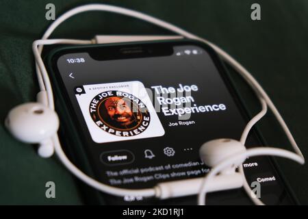 Il podcast Joe Rogan Experience su Spotify visualizzato sullo schermo di un telefono e le cuffie sono visibili in questa foto di illustrazione scattata a Cracovia il 3 febbraio 2022. (Foto Illustrazione di Jakub Porzycki/NurPhoto) Foto Stock