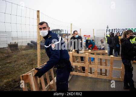 I poliziotti rimuovono i pallet posti dagli attivisti vicino all'ingresso del cantiere. Diverse decine di attivisti di XR, ANV-COP21, ATTAC, Gioventù per il clima si sono riuniti a Saint Sulpice la Pointe per bloccare il cantiere del gigantesco magazzino del Terra2. Si oppongono a un gigantesco magazzino progettato per Amazon o Alibaba e che copre diversi campi agricoli. Il capannone principale shoud è di 533 m di lunghezza, 125m di larghezza e 17m di altezza, sarebbe nella top 10 dei più grandi magazzini in Francia. I lavori di costruzione non dovrebbero essere iniziati quest'inverno perché la fermata Terra2 ha chiesto alla giustizia di giudicare l'l Foto Stock