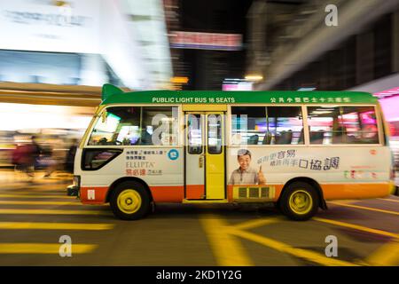 Un minibus verde passa a Mongkok in un panned shot., a Hong Kong, Cina, il 5 febbraio 2022, A Hong Kong, Cina, il 5 febbraio 2022. (Foto di Marc Fernandes/NurPhoto) Foto Stock