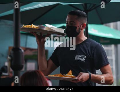 Un cameriere che indossa una maschera per il viso serve cibo in uno dei bar del centro di Merida. Lunedì 07 febbraio 2022, a Merida, Yucatan, Messico. (Foto di Artur Widak/NurPhoto) Foto Stock