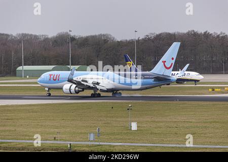 L'aeromobile TUI utilizza spintori inversi per frenare mentre passa davanti a un Boeing Ryanair 737-800. TUI Airlines Belgium Boeing 767-300ER velivolo visto in arrivo in volo, atterraggio sulla pista e tassazione all'aeroporto Eindhoven EIN che esegue una rara rotta nazionale olandese. Il velivolo Boeing B767, con un corpo largo, arriva dall'aeroporto Schiphol di Amsterdam e ha come destinazione un volo charter per Bardufoss in Norvegia con il volo numero OR9531. Il jet plane ha la registrazione OO-JNL e il nome Sunshine. TUI fly ex Jetairfly, ArkeFly, è un aereo belga di linea e cha Foto Stock