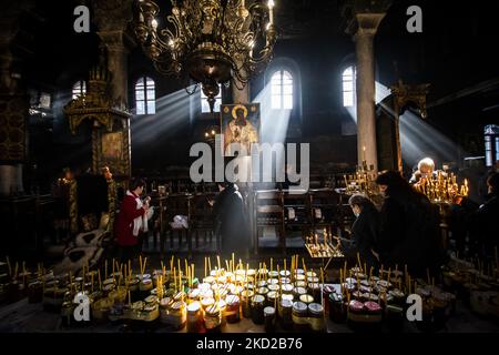 I fedeli illuminano le candele su vasi con miele durante un rituale religioso che segna il giorno di San Haralampi - il santo protettore ortodosso degli apicoltori - nella chiesa della Presentazione della Beata Vergine, a Blagoevgrad, Bulgaria occidentale, il 10 febbraio 2022. (Foto di Georgi Paleykov/NurPhoto) Foto Stock