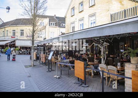 Vita quotidiana a Valkenburg aan de Geul o Valkenberg con persone che si godono il sole sulle terrazze dei caffè e ristoranti, come i negozi riaprono dopo il blocco invernale per combattere la pandemia di coronavirus Covid-19. Valkenburg è una storica città olandese nella provincia di Limburgo con il fiume Geul con i famosi caffè, bar, taverne e ristoranti, una destinazione turistica e di viaggio. La città è stata colpita dalle alluvioni dell'estate 2021 dopo il tempo estremo, le forti precipitazioni e gli alti livelli d'acqua che hanno provocato le evacuazioni. Valkenburg, Paesi Bassi il 5 febbraio 2022 (Foto di Nicolas Economou Foto Stock