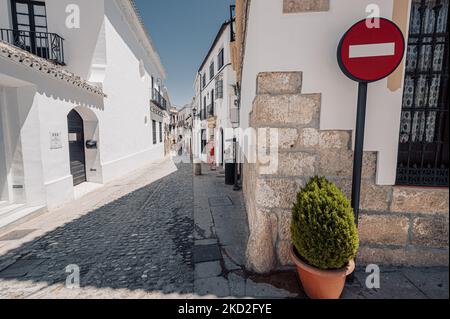 Un bellissimo scatto di case tradizionali con pareti bianche all'angolo di una strada lastricata in pietra a Ronda Andalusia Spagna Foto Stock
