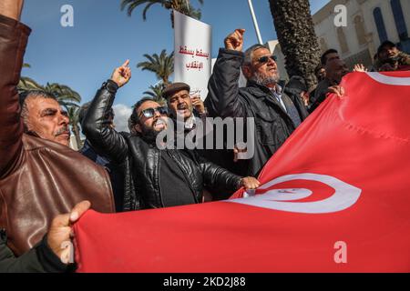 I sostenitori del partito di ispirazione islamista Ennahda urlano slogan in quanto detengono una gigantesca bandiera tunisina durante una manifestazione organizzata su iniziativa dei “cittadini contro il colpo di stato – l’iniziativa democratica”, sulla via Mohamed 5 nella capitale Tunisi, il 13 febbraio 2022, Per protestare contro lo scioglimento del Consiglio giudiziario supremo del paese e per l’indipendenza della magistratura. I manifestanti hanno anche chiesto il rilascio del vicepresidente del partito Ennahda, Noureddine Bhiri, che è stato messo agli arresti domiciliari da più di sei settimane. Anche i dimostranti hanno protestato contro un Foto Stock