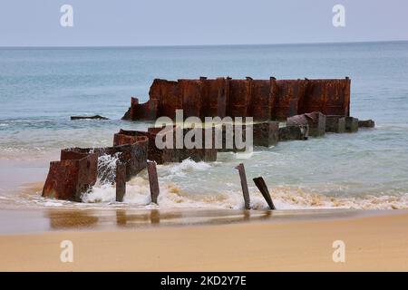 Resti di metallo arrugginito della nave Farah 3 presso l'oceano lungo la spiaggia di Mullaitivu, Sri Lanka. Questa è una delle tante cicatrici della guerra civile durata 26 anni tra l'esercito dello Sri Lanka e le LTTE (Liberation Tigers of Tamil Eelam). La nave Farah 3 era una nave mercantile di proprietà giordana. Mentre era sulla sua strada dalla costa di Andhra Pradesh in India al Sud Africa, ha sviluppato problemi motori, e ha dovuto ancorare al largo della costa di Mullaitivu. Le Tigri del mare di LTTE dirottarono la nave e presero il suo prigioniero dell'equipaggio nel dicembre 2006 e trascinarono la nave più vicino alla costa dove si arenò alla p Foto Stock