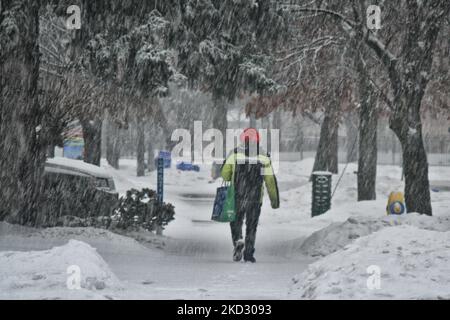 Uomo che cammina durante le nevicate pesanti come una tempesta invernale ha colpito Toronto, Ontario, Canada, il 17 febbraio 2022. La tempesta è iniziata con la liberazione di pioggia e pellet di ghiaccio e poi è passata a nevicate pesanti con quantità totali di 15 - 20 cm di neve prevista attraverso la Greater Toronto Area questa sera fino a Venerdì mattina. (Foto di Creative Touch Imaging Ltd./NurPhoto) Foto Stock