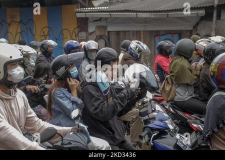 Gli ufficiali congiunti danno maschere agli automobilisti in mezzo ai timori di un'altra ondata di scoppio del coronavirus il 20 febbraio 2022, a Cimahi, Giava Occidentale, Indonesia. L'Indonesia è in fase di crescita per la terza ondata di infezioni da COVID-19, poiché la variante altamente trasmissibile di omicron genera un'impennata in nuovi casi. (Foto di Algi Libri Sugita/NurPhoto) Foto Stock