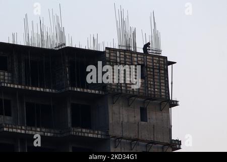 Un lavoratore fissa le verghe di ferro nel sito di costruzione di un edificio in un quartiere residenziale a Ghaziabad, alla periferia di Nuova Delhi, India il 20 febbraio 2022. (Foto di Mayank Makhija/NurPhoto) Foto Stock