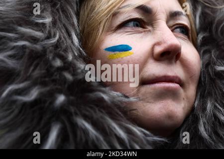 Una donna con una bandiera Ucraina dipinta sulla guancia partecipa a una protesta contro l'agressione russa in Ucraina, a Cracovia, Polonia, il 20 febbraio 2022. La manifestazione è organizzata man mano che la tensione al confine russo-ucraino continua. (Foto di Jakub Porzycki/NurPhoto) Foto Stock