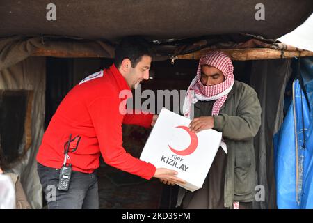 Direttore della Mezzaluna Rossa turca ''Ibrahim Altan'' con i volontari che distribuiscono aiuti umanitari nei campi di Kafr Yahmoul nella campagna dell'Ida, nella Siria nordoccidentale, il 21 febbraio 2022. (Foto di rami Alsayed/NurPhoto) Foto Stock