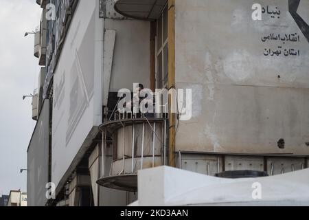 Un uomo iraniano usa il suo smartphone mentre si trova su un balcone di un centro commerciale di computer nel nord di Teheran il 23 febbraio 2022. Diversi membri del parlamento hanno sottolineato in una riunione pubblica del 23 febbraio che il piano di organizzare i servizi di cyberspazio non è inteso a bloccare lo spazio virtuale, mentre secondo l'ISNA, i membri della commissione per la protezione dei diritti degli utenti nel ciberspazio nella riunione odierna della commissione, con 18 voti, hanno approvato il progetto di legge. (Foto di Morteza Nikoubazl/NurPhoto) Foto Stock