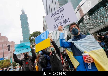 Manifestanti che detengono cartelli con la dicitura “Siamo tutti ucraini oggi”, e bandiere nazionali dell’Ucraina, durante una protesta contro gli attacchi russi contro l’Ucraina, al di fuori della commissione di coordinamento Mosca-Taipei a Taiwan, a Taipei, Taiwan, 25 febbraio 2022. Diversi paesi occidentali, tra cui Stati Uniti e Regno Unito, hanno imposto sanzioni alla Russia, mentre i membri degli stati baltici, tra cui Lituania ed Estonia, hanno mostrato il sostegno all'Ucraina. (Foto di Ceng Shou Yi/NurPhoto) Foto Stock