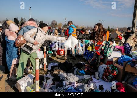 Un volontario dà via una coperta alla donna Ucraina dopo essere arrivata in Polonia, mentre decine di migliaia di rifugiati dall'Ucraina entrano in Polonia al valico di frontiera di Medyka, 26 febbraio 2022. Mentre l'esercito della Federazione Russa ha attraversato i confini ucraini, il conflitto tra Ucraina e Russia dovrebbe costringere alla fuga 5 milioni di ucraini. La maggior parte dei rifugiati dovrebbe cercare asilo in Polonia. La maggior parte degli attuali rifugiati sono famiglie di quegli ucraini che già lavorano in Polonia. I valichi di frontiera sono pieni di migliaia di uomini e donne in attesa della loro amata una volta. (Foto di Dominika Zarzycka/NurPhot Foto Stock