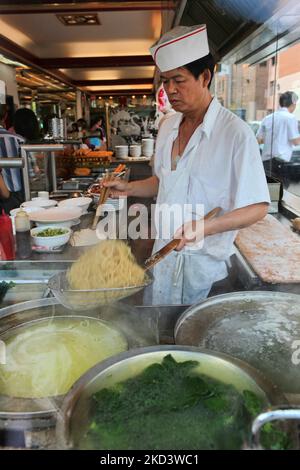 Lo chef cinese cucina tagliatelle e verdure su una stufa calda in una cucina ristorante a Chinatown a Toronto, Ontario, Canada. (Foto di Creative Touch Imaging Ltd./NurPhoto) Foto Stock