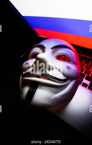 La bandiera russa visualizzata sullo schermo di un computer portatile e la maschera Guy Fawkes sono visibili in questa foto di illustrazione scattata a Cracovia il 1 marzo 2022. Il gruppo globale di hacker Anonimo ha dichiarato 'guerra cibernetica' contro la Russia. (Foto di Jakub Porzycki/NurPhoto) Foto Stock