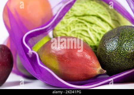Rete in tessuto per frutta e verdura su fondo bianco. Un'alternativa riutilizzabile ai sacchetti di plastica. Foto Stock