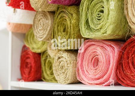 Rotoli di tessuto per cucire. Fili multicolore di colore verde, rosa, rosso. Strumenti di Unione. Filati, maglieria, uncinetto, seta, lino, fatti a mano, sintetici Foto Stock