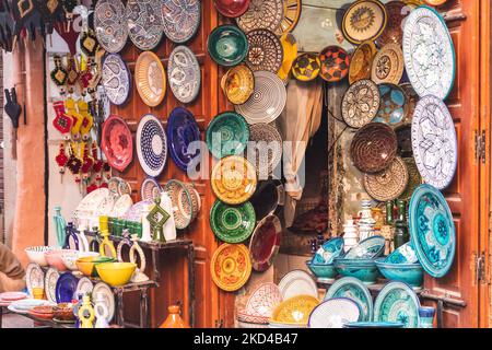 Un negozio nella Medina / Souks di Marrakech che vende piatti decorati con colori, ceramiche e altri oggetti. Foto Stock