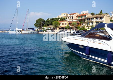 Barche nella baia di una piccola città greca sull'isola di Corfù Foto Stock