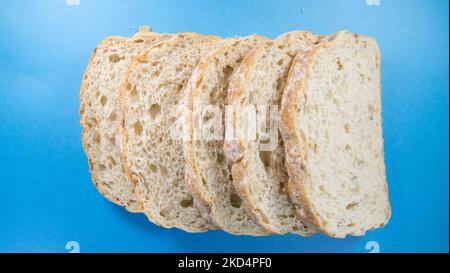 cinque fette di pane fresco seminato isolato su uno sfondo blu scuro Foto Stock