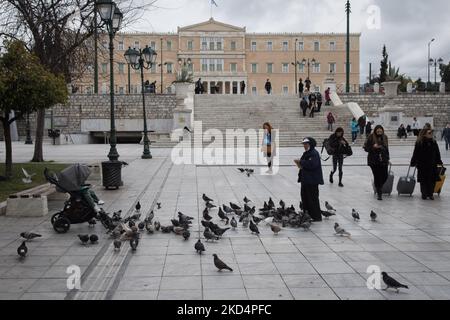 Una donna si nutre e fotografa il suo bambino piccioni davanti al Parlamento greco nel centro di Atene, in Grecia, il 10 marzo 2022. (Foto di Nikolas Kokovlis/NurPhoto) Foto Stock