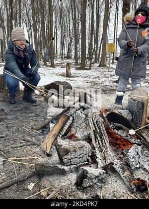 Persone che brinda marshmallows da un piccolo fuoco mentre visitano il sugarbush in una fattoria di sciroppo d'acero durante il Festival dello zucchero d'acero a Mount Albert, Ontario, Canada, il 05 marzo 2022. Il Festival dello zucchero d'acero celebra la produzione di sciroppo d'acero e i prodotti realizzati con sciroppo d'acero e partecipa a molte aziende agricole produttrici di sciroppo d'acero in Ontario e Quebec. Lo sciroppo d'acero è prodotto solo in Nord America. (Foto di Creative Touch Imaging Ltd./NurPhoto) Foto Stock